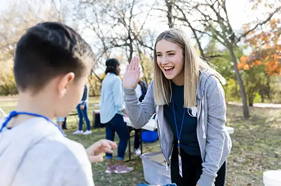 Lady greeting a young volunteer